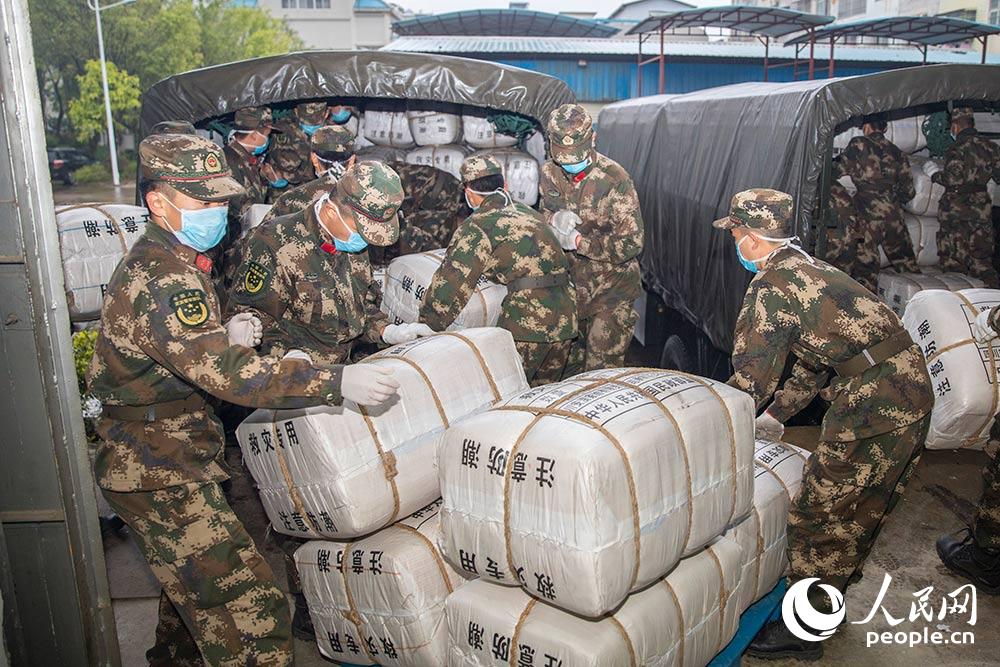 2月9日，武警官兵正在搬运救援物资。