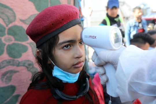 3月2日，在伊拉克巴格达解放广场，一名女孩接受体温检测。新华社发(哈利勒·达伍德摄)