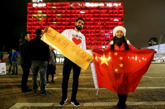 2月11日，在以色列特拉维夫市政大楼前，在以华人和以民众表达对中国的祝福。新华社发(吉尔·科恩·马根摄)