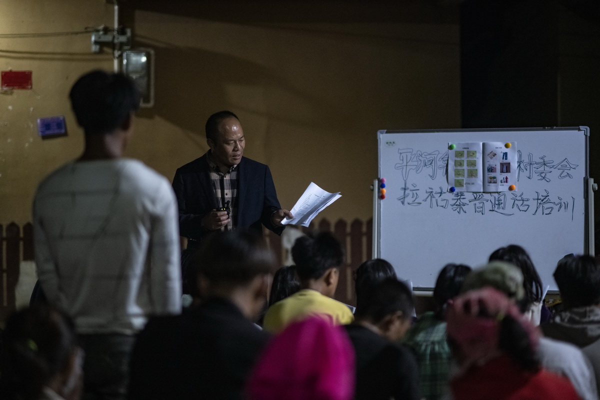 村民们利用夜间空闲时间，在院子里集体学习普通话（3月28日摄）。