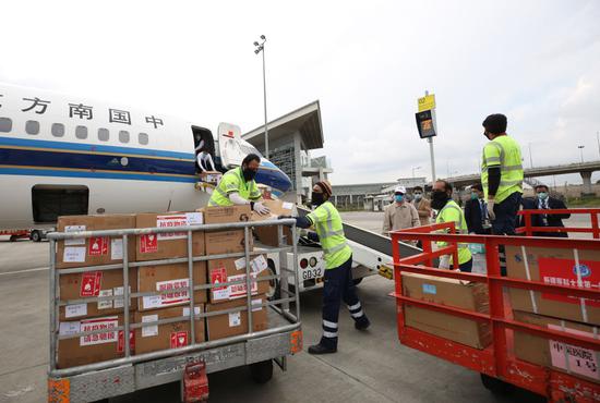  3月28日，在巴基斯坦伊斯兰堡国际机场，工作人员卸载中国捐赠的医疗救治物资。（新华社记者刘天摄）