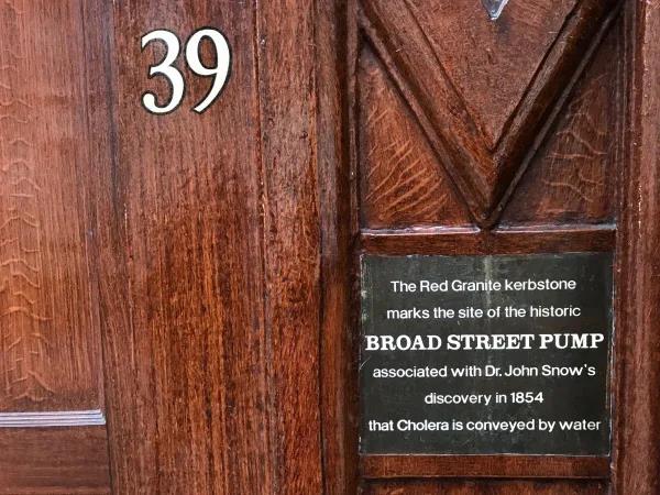 ▲ 斯诺酒吧的老木门上，镶嵌着当年纪念斯诺和压水井的铭牌。图片来源：澎湃新闻