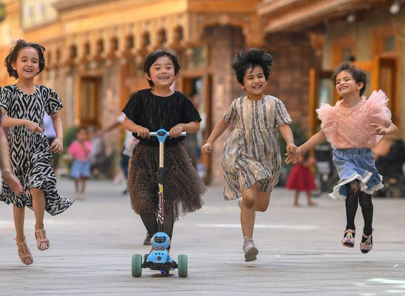 孩子们在新疆和田市鸽子巷奔跑玩耍（5月27日摄）。