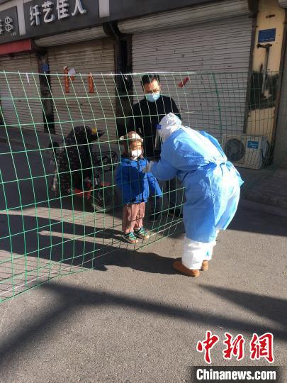 1月8日一早，医疗队护士李凯的丈夫特地带着4岁的儿子赶来，多日不见的一家三口隔着防护网“团聚”了一分钟。图片由陆军军医大学士官学校附属医院提供