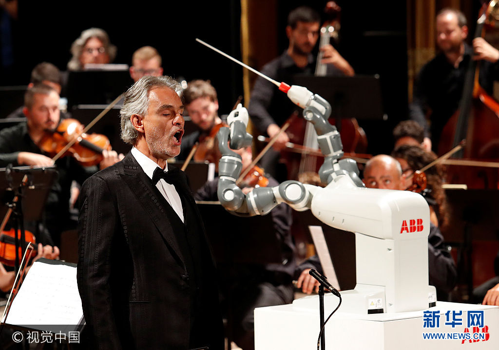 当地时间2017年9月12日，意大利比萨，意大利男高音歌唱家安德烈·波切利(Andrea Bocelli)与卢卡爱乐乐团合作演出，他的指挥由瑞典科技公司ABB制造的双臂机器人YuMi担任。***_***Humanoid robot YuMi conducts the Lucca Philharmonic Orchestra performing a concert alongside Italian tenor Andrea Bocelli at the Verdi Theatre in Pisa, Italy September 12, 2017. Remo Casilli