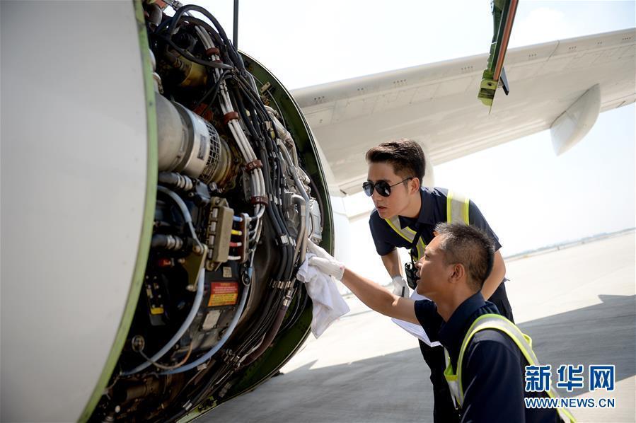 8月10日,南方航空西安分公司机务郝清华(右),周磊在检查发动机油液