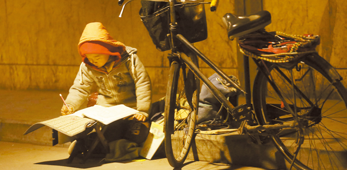 路灯下写作业的男孩