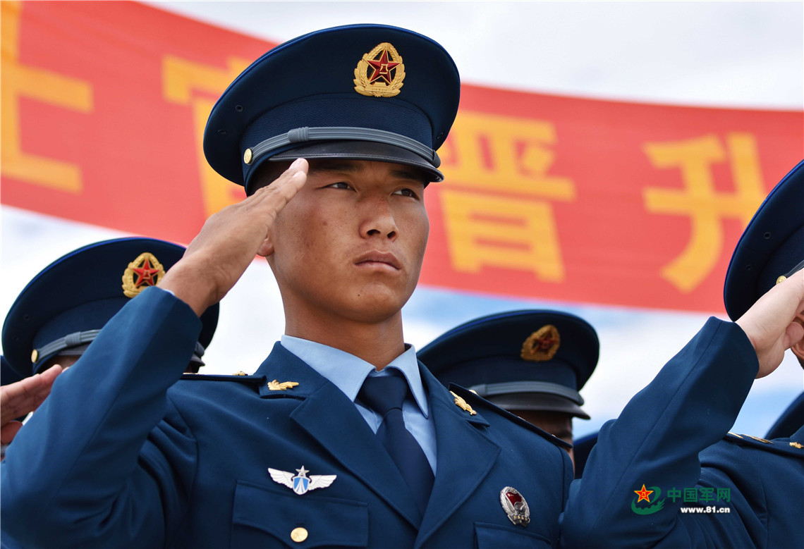 戴上新军衔,士官们向军旗庄重敬礼.