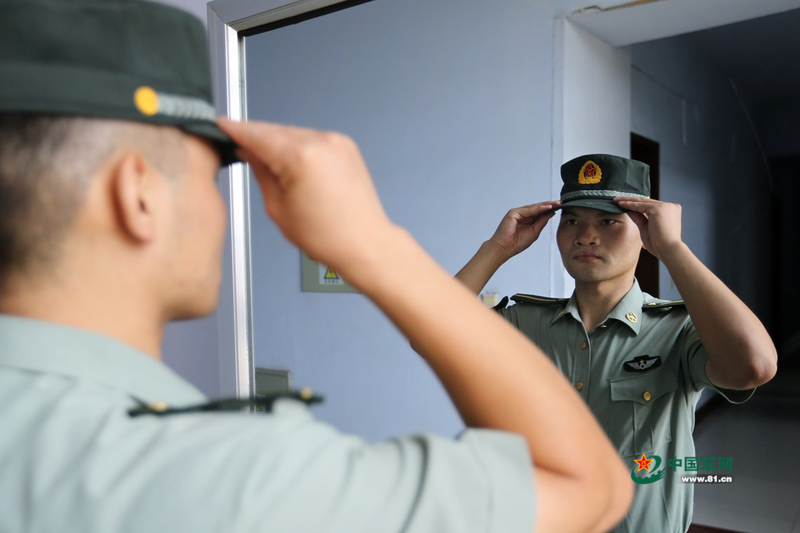 一名新排长正在军容镜前整理军容.