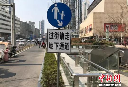 路口的标志牌上清楚的写着:过街请走地下通道. 孙权 摄