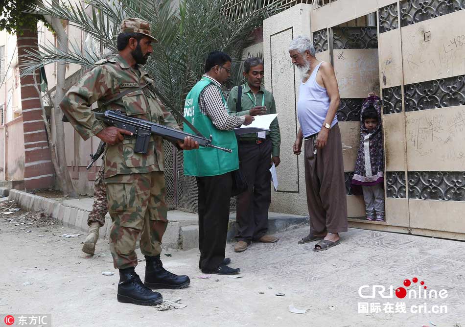 当地时间2017年3月15日,巴基斯坦卡拉奇,士兵护卫人口普查官员进行