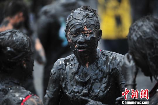 云南沧源上演疯狂的"泥巴盛宴" 游客秒变"黑人"