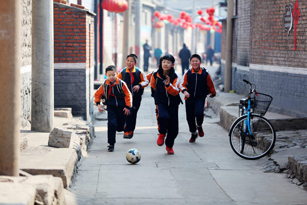 苏斌摄2018年3月,山西平定娘子关一所学校的学生在放学路上踢球回家
