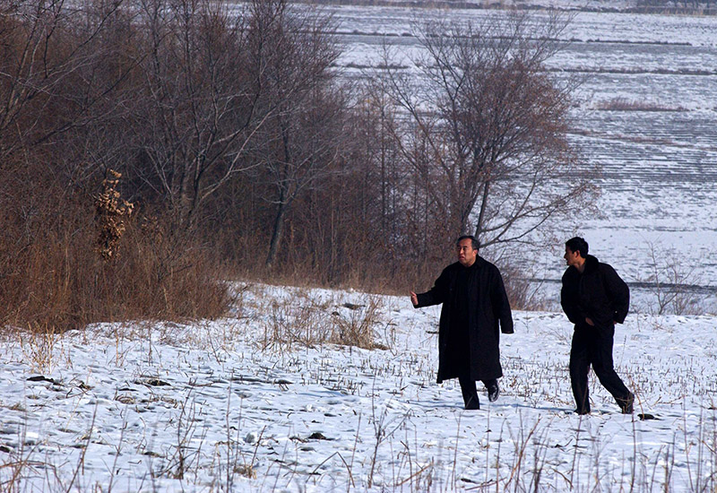 2003年2月7日,在黑龙江省齐齐哈尔市拜泉县,王树清(左)在检查植树
