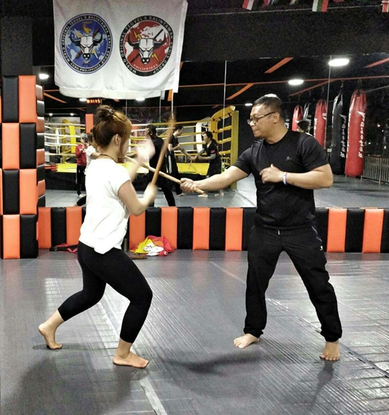 菲律宾教练向中国学员讲解,传授短棍术.艳杰/摄